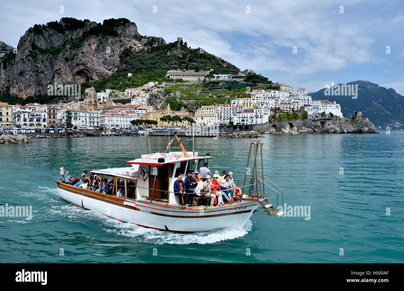 Tour boat in front of town Amalfi, Amalfi Coast, Costiera Amalfitana, Province of Salerno, Campania, Italy Stock Photo