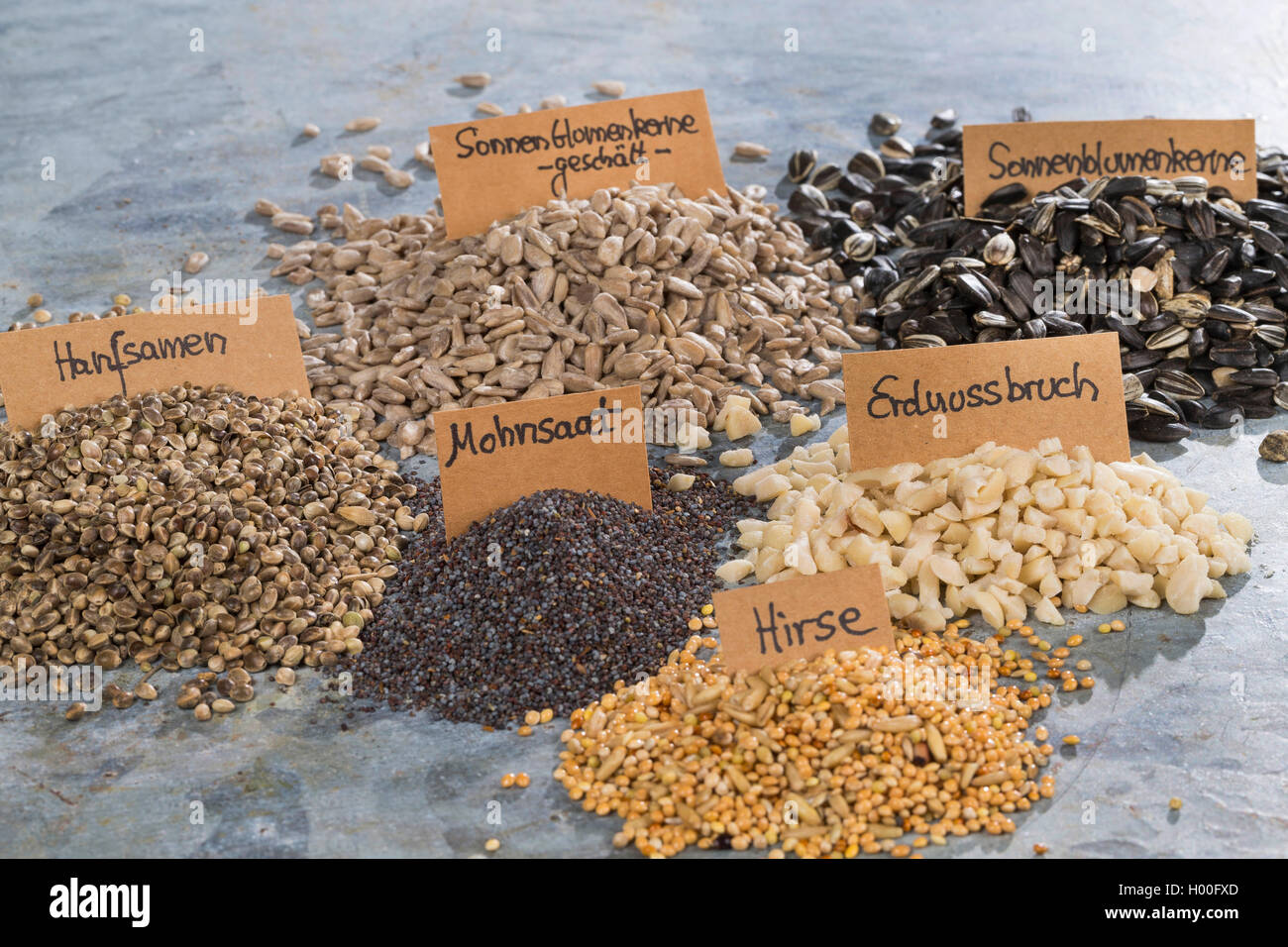 Zutaten fuer selbstgemachtes Vogelfutter, Hanfsamen, Erdnussbruch, Sonnenblumenkerne, Mohnsaat und Hirse | ingredients for selfm Stock Photo