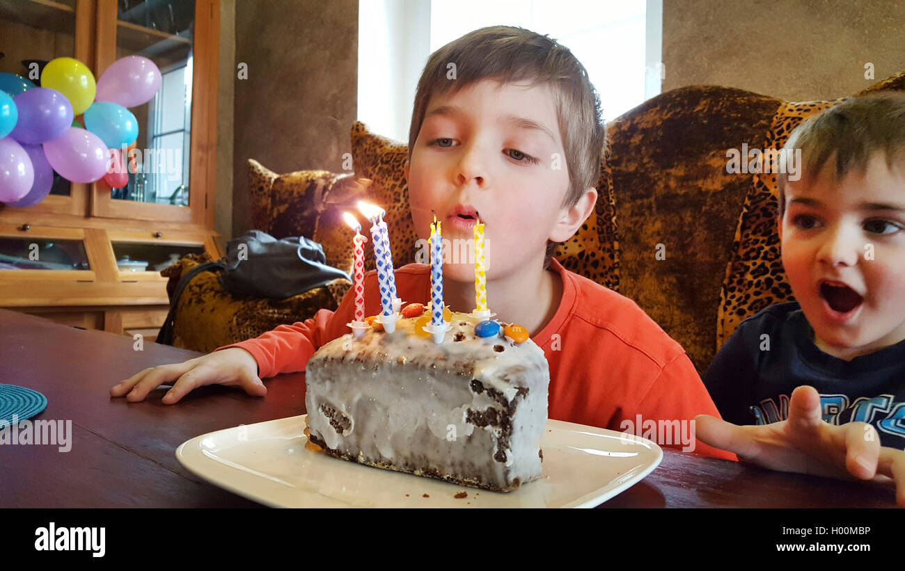 Junge pustet Kerzen vom Geburtstagskuchen aus, Deutschland | boy blowing out the candles from the birthday cake, Germany | BLWS4 Stock Photo