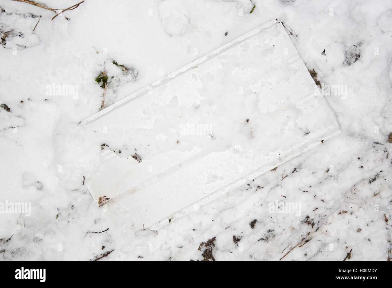 Broken sledges, trays and other pieces of rubbish litter the Roman Amphitheatre in Cirencester, Gloucestsershire Uk. The items have been left after days of sledging and playing in the snow, leaving the area looking like a battleground. Stock Photo