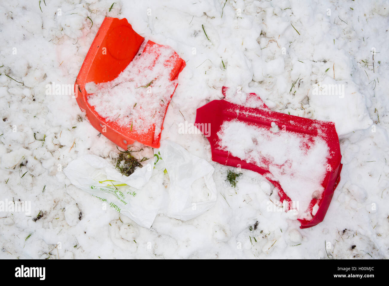 Broken sledges, trays and other pieces of rubbish litter the Roman Amphitheatre in Cirencester, Gloucestsershire Uk. The items have been left after days of sledging and playing in the snow, leaving the area looking like a battleground. Stock Photo