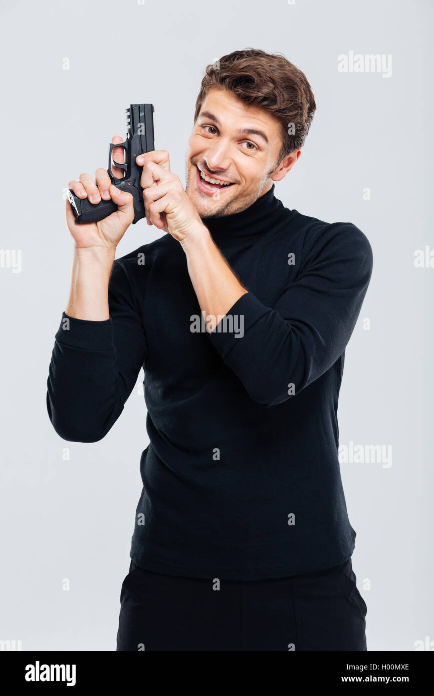 Young handsome man holding hand gun hires stock photography and images