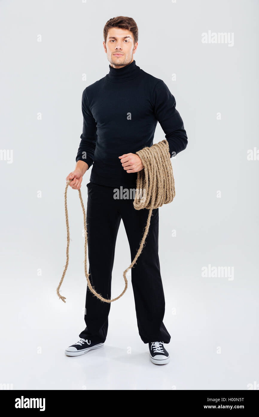 Full Length Of Man Criminal Burglar Standing And Holding Rope Stock