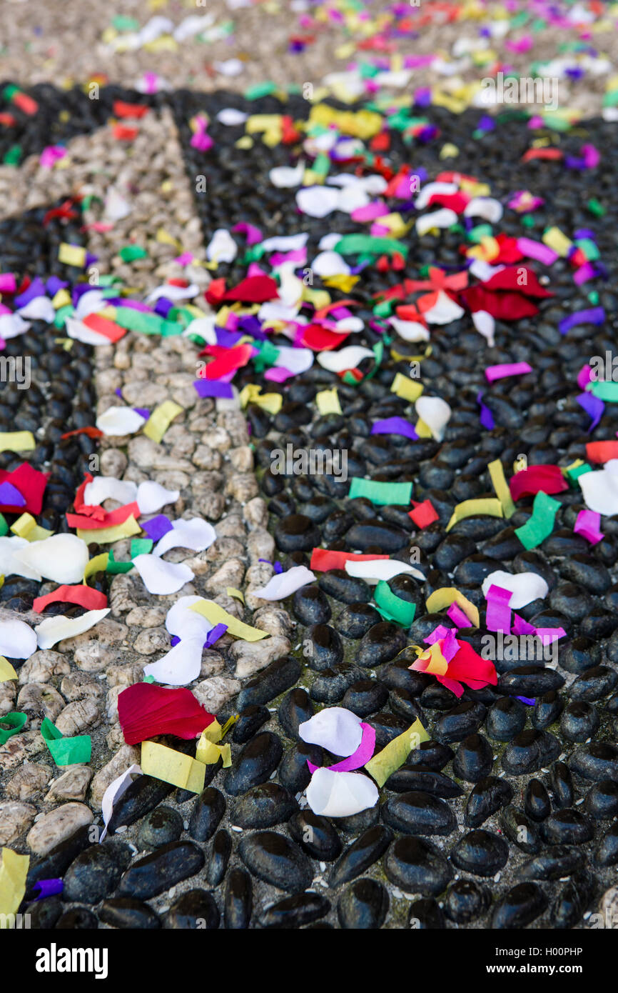 Cobbled path covered in colourful confetti in a small Italian town near