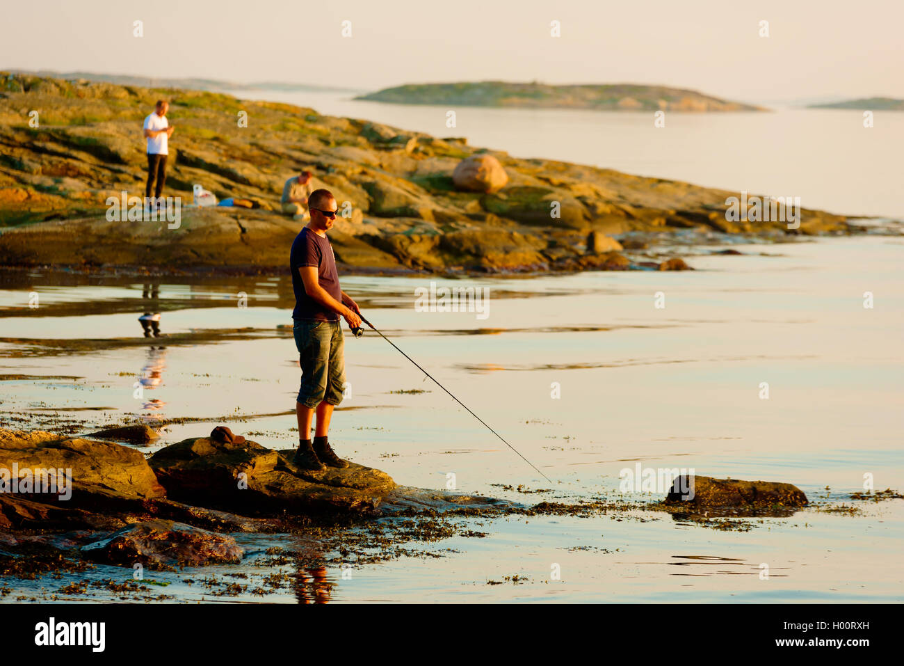 Marstrand, Sweden - September 8, 2016: Documentary of coastal recreational fishing in the evening sunlight. Water is calm and wi Stock Photo