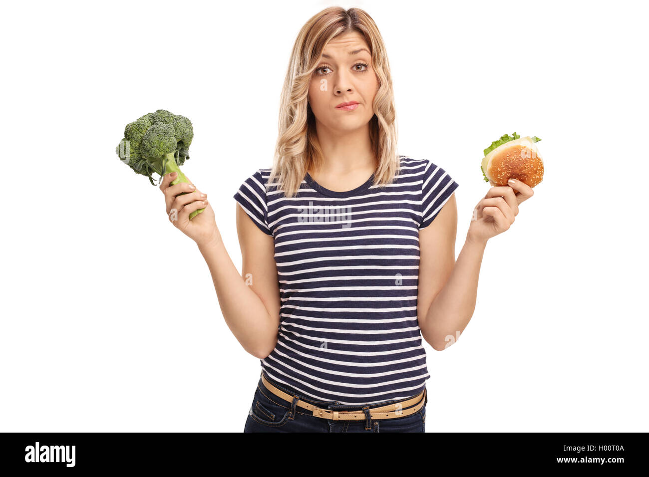Sad woman holding a sandwich and broccoli isolated on white background Stock Photo
