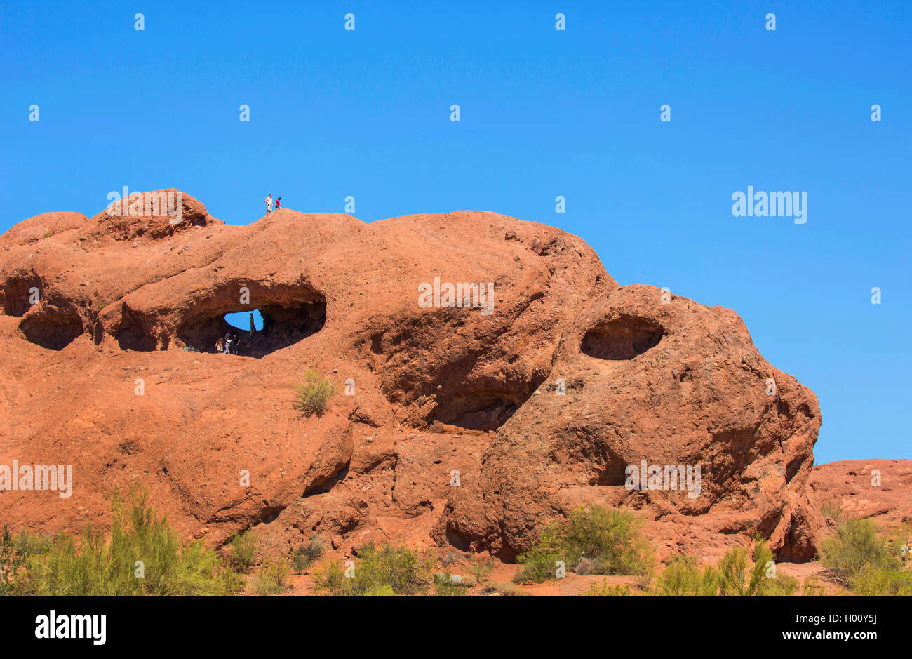 Hole-in-the-Rock, cave in red sandstone with climbing tourists, USA, Arizona, Papago Park, Phoenix Stock Photo