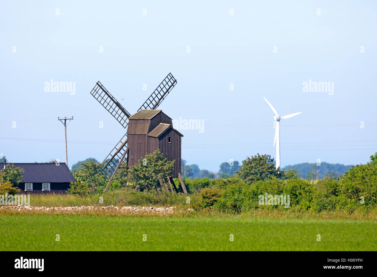 Holzwindmuehle und Windrad in der Kulturlandschaft, Schweden, Oeland | windmill and wind turbine in the cultural landscape, Swed Stock Photo