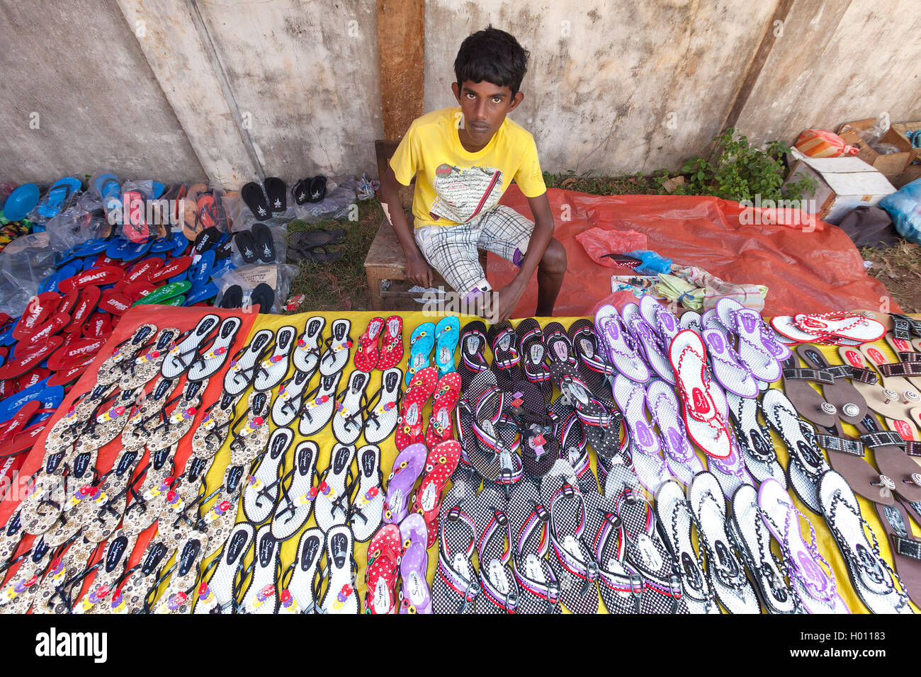 HIKKADUWA, SRI LANKA - FEBRUARY 23, 2014: Young local street vendor selling  sandals. The Sunday market is great way to see local Stock Photo - Alamy