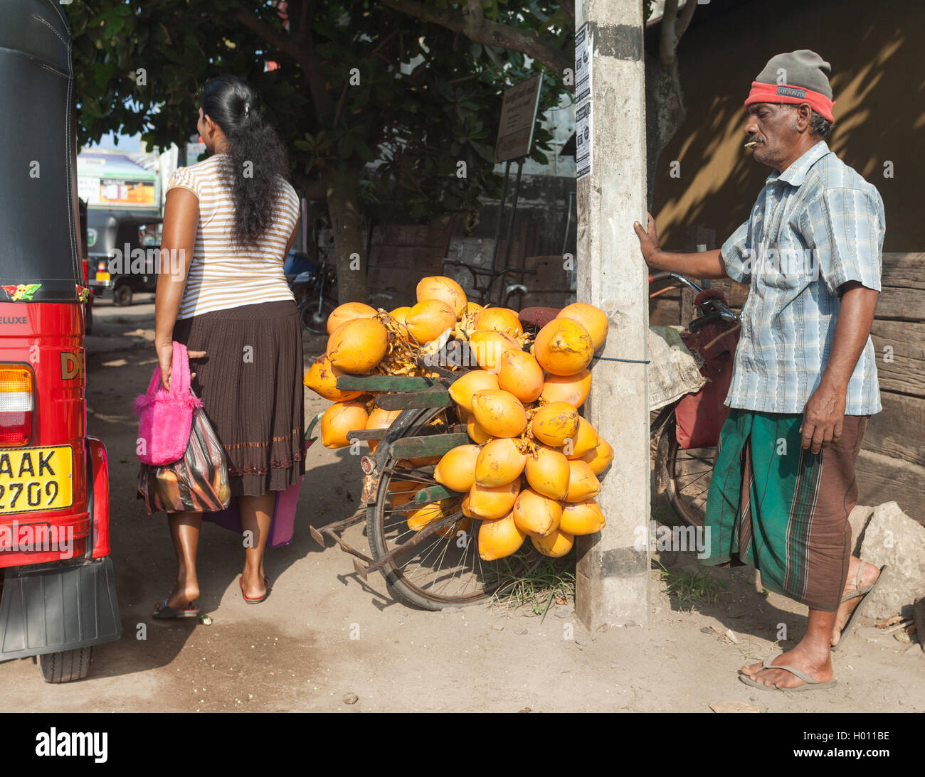 HIKKADUWA, SRI LANKA - MARCH 9, 2014: Local man selling fruit on his bike at street. Cycling is the main transportation for the Stock Photo