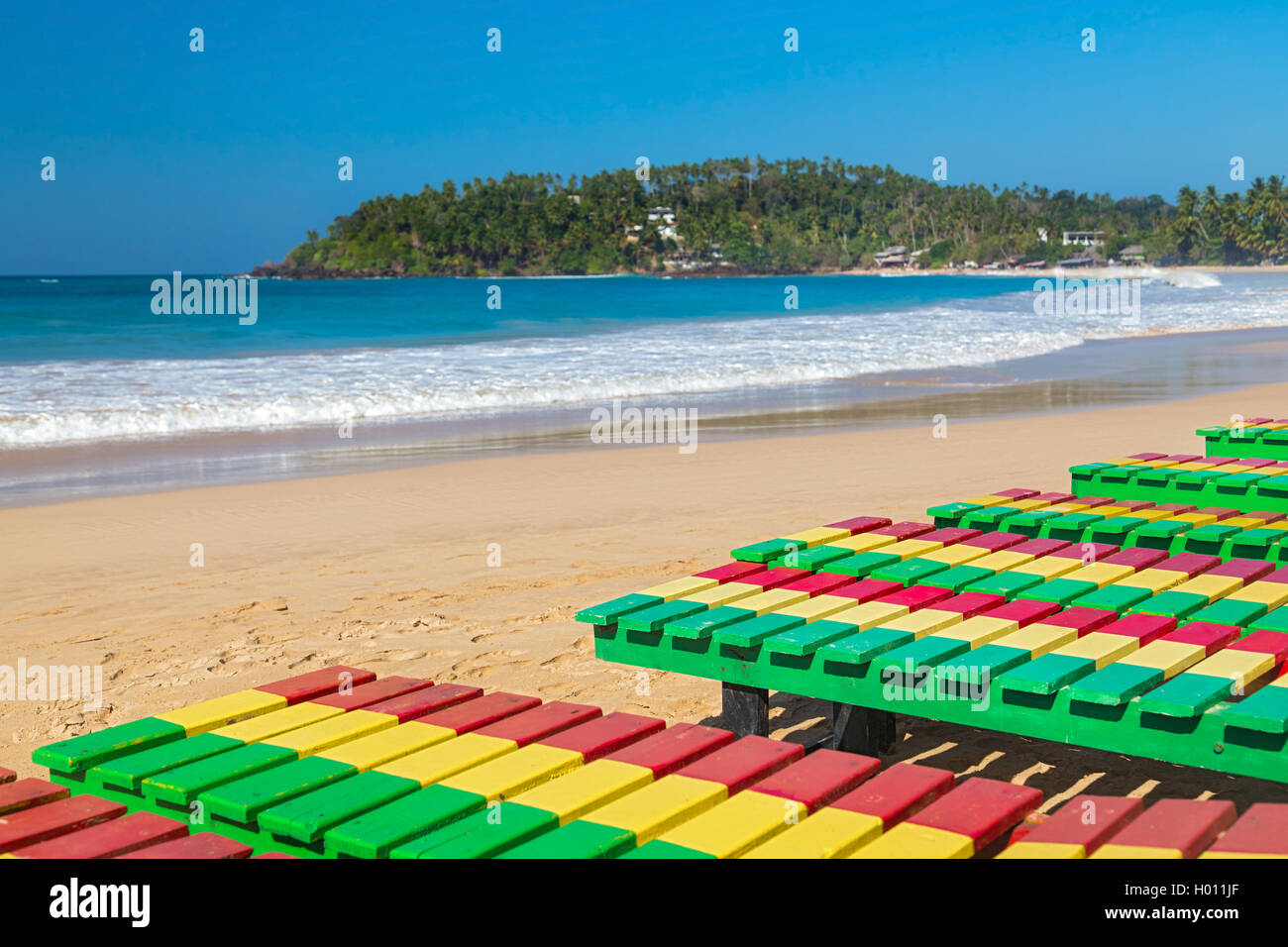 Colourful wooden deck chairs on Unawatuna beach in Sri Lanka Stock