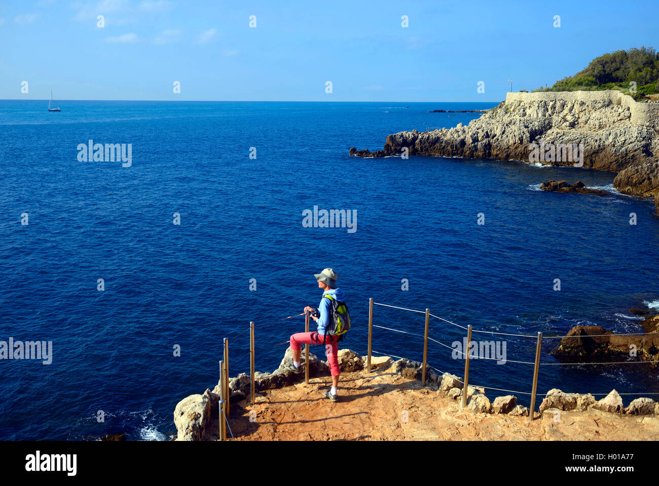 woman at a viewpoint over the rocky coast of the Cote d'Azur, France, Alpes Maritimes, Antibes Stock Photo