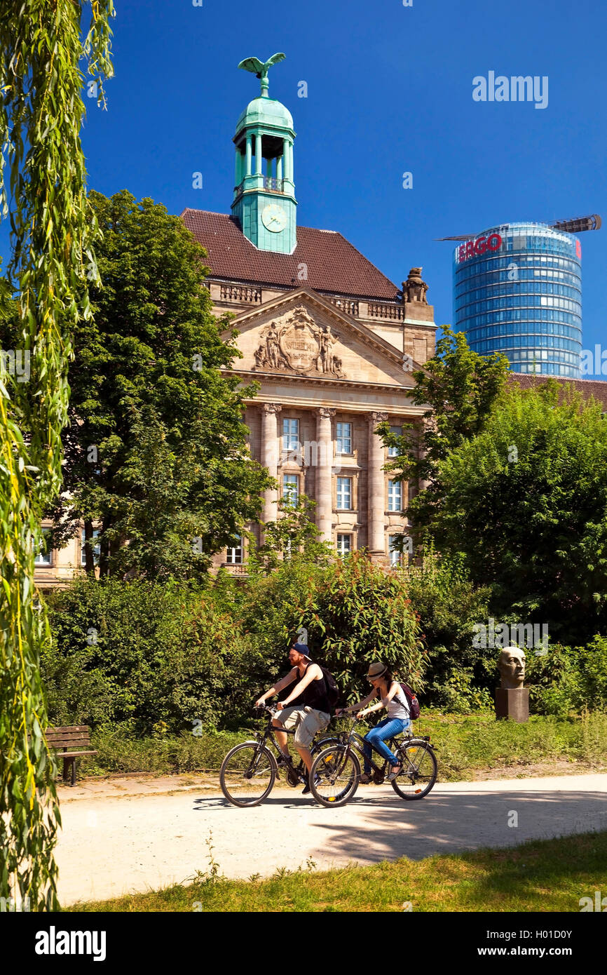 two bicyclists in front of the legislative building of the county and the tower block of the Ergo office tower, Germany, North Rhine-Westphalia, Duesseldorf Stock Photo