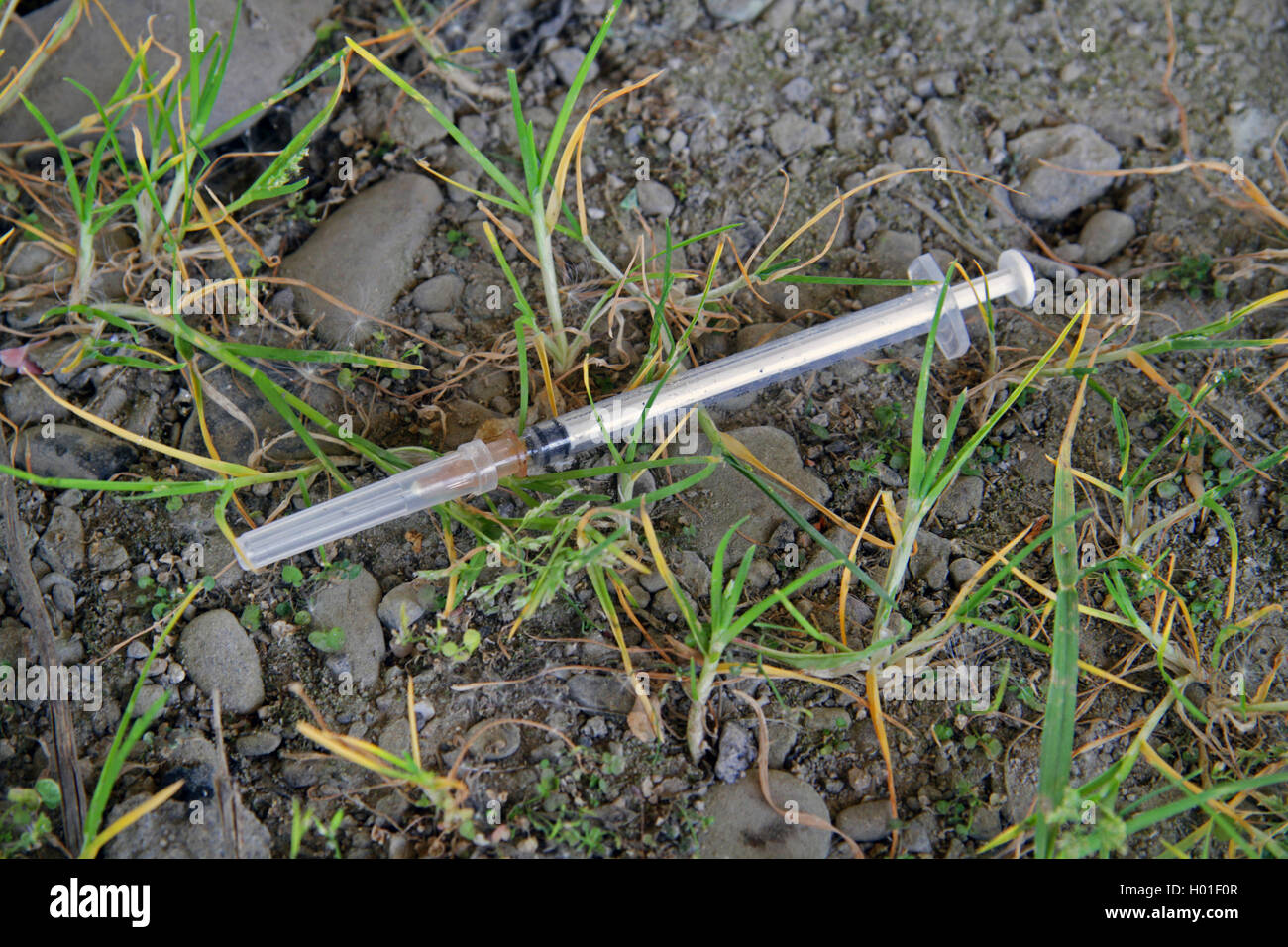 heroin syringe on the ground, Germany Stock Photo