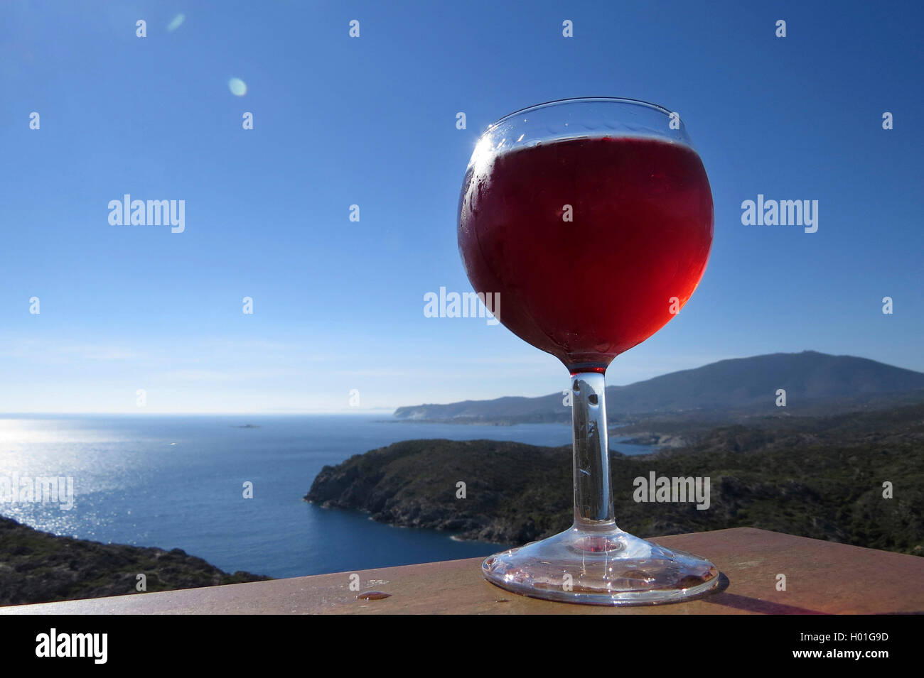 red vine glass in front of coastal landscape, Spain, Katalonia Stock Photo