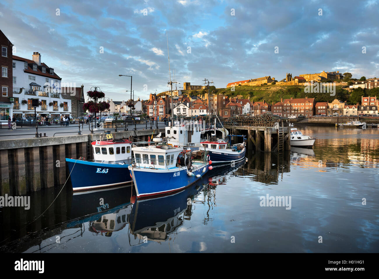 The harbour, Whitby, North Yorkshire, UK. The Abbey and St Mary's Chuch are seen on the cliff top above. Stock Photo