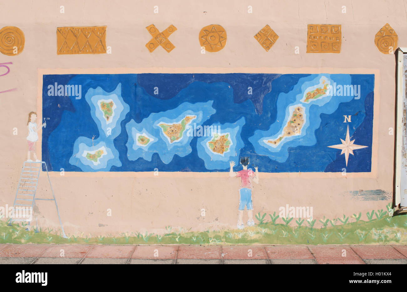 Fuerteventura, Canary Islands, North Africa, Spain: a mural with a child looking at the map of the Canary Islands in the fishing village of El Cotillo Stock Photo