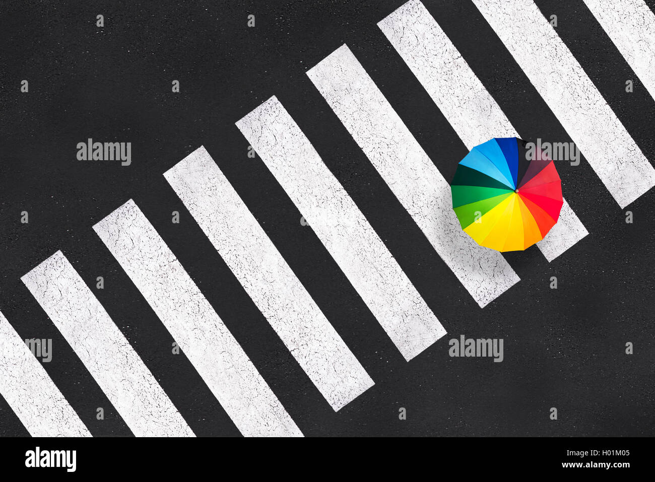 Top view of a rainbow umbrella on a pedestrian crosswalk Stock Photo