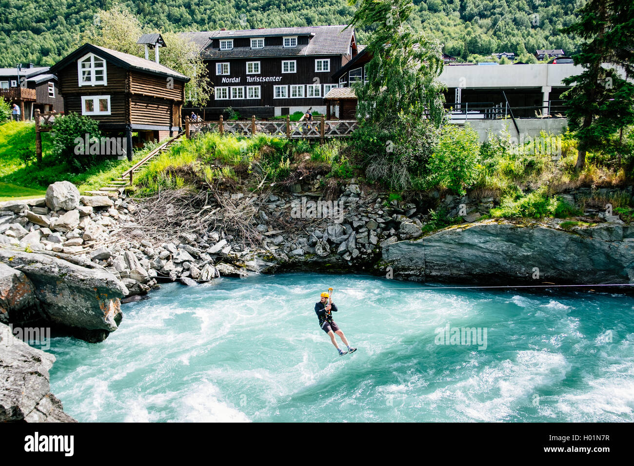 A turist on a Tyrolean traverse over Bovra river in the city of Lom, Oppland Norway Stock Photo