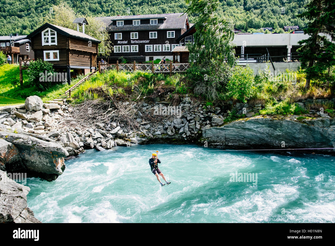 A turist on a Tyrolean traverse over Bovra river in the city of Lom, Oppland Norway Stock Photo