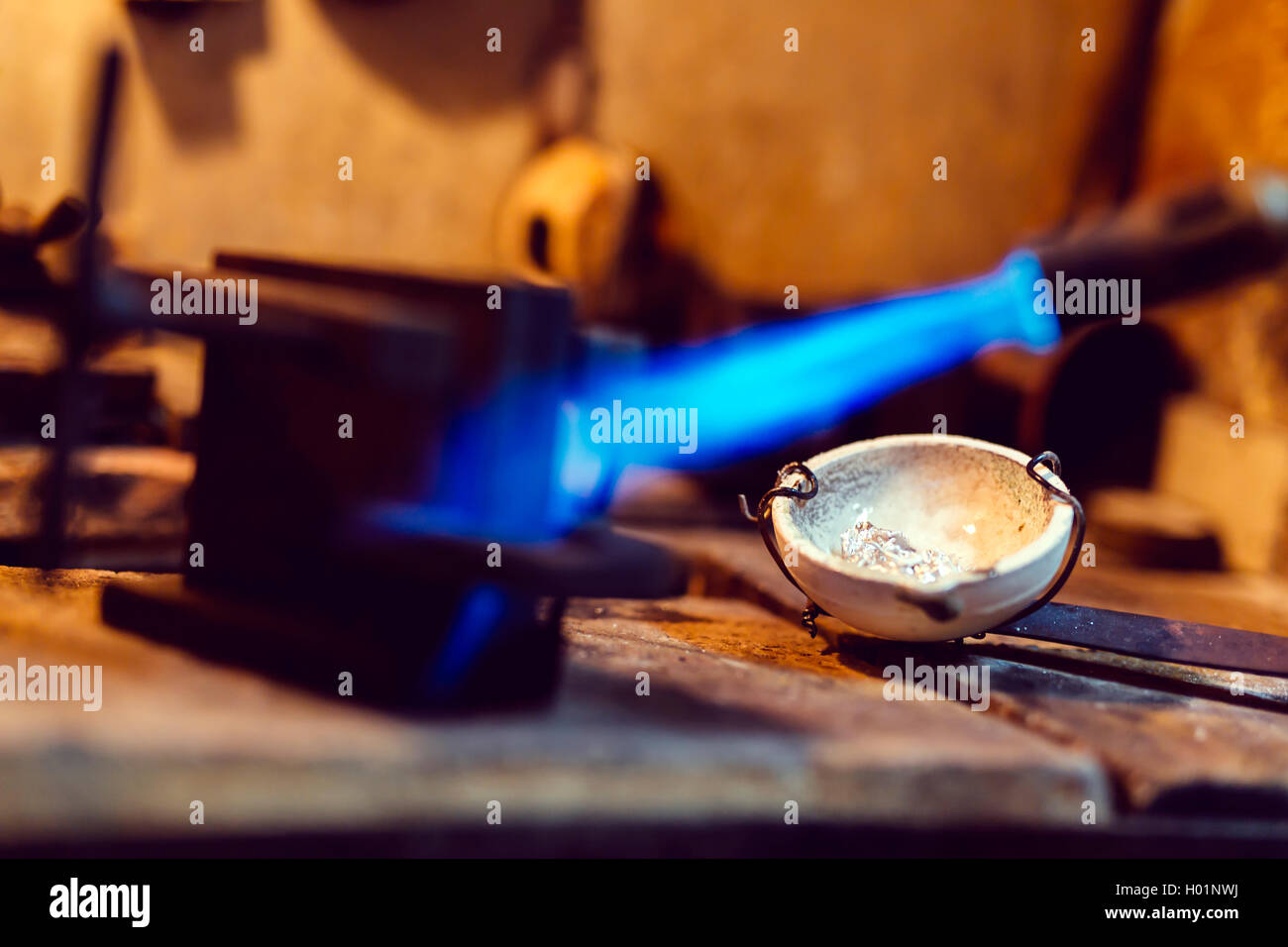 Jeweler using tourch to heat welding tools to proper temperature Stock Photo
