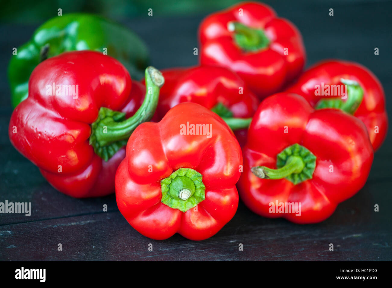 Group of fresh red peppers on a wooden table Stock Photo - Alamy