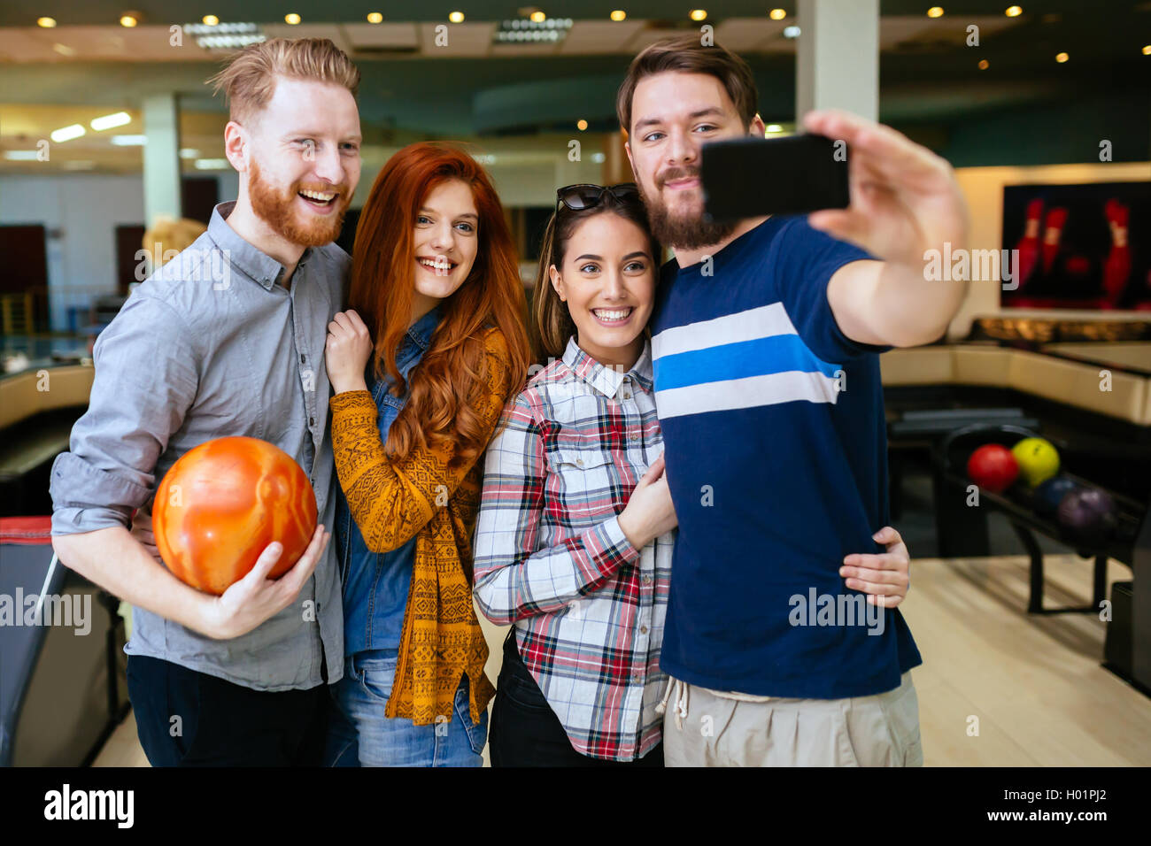 Friends taking selfies of themselves bowling Stock Photo