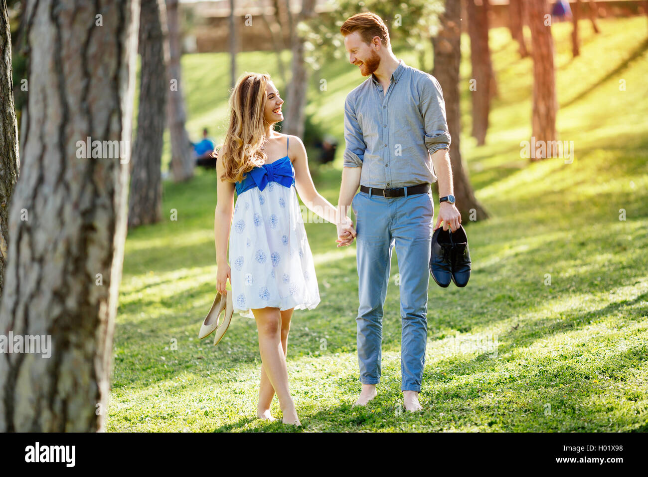 Couple enjoying romantic walk in nature barefoot Stock Photo - Alamy