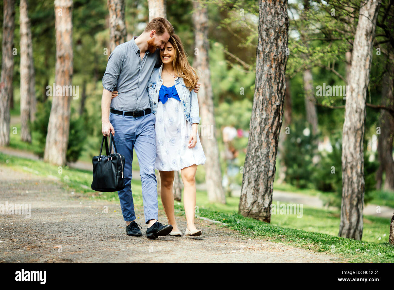 Beautiful couple taking a walk in city park Stock Photo - Alamy
