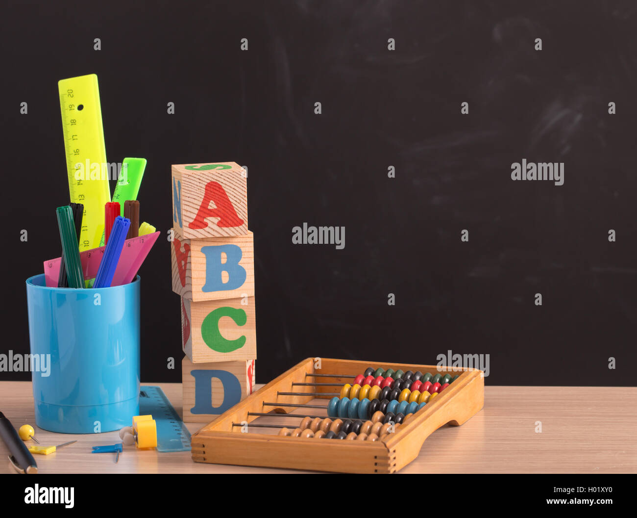 Various school supplies against black board Stock Photo
