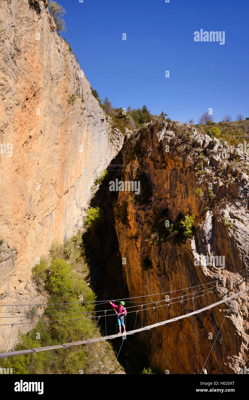 female climber on hanging bridge, via ferrata de la Grande Fistoire, France, Caire, Sisteron Stock Photo
