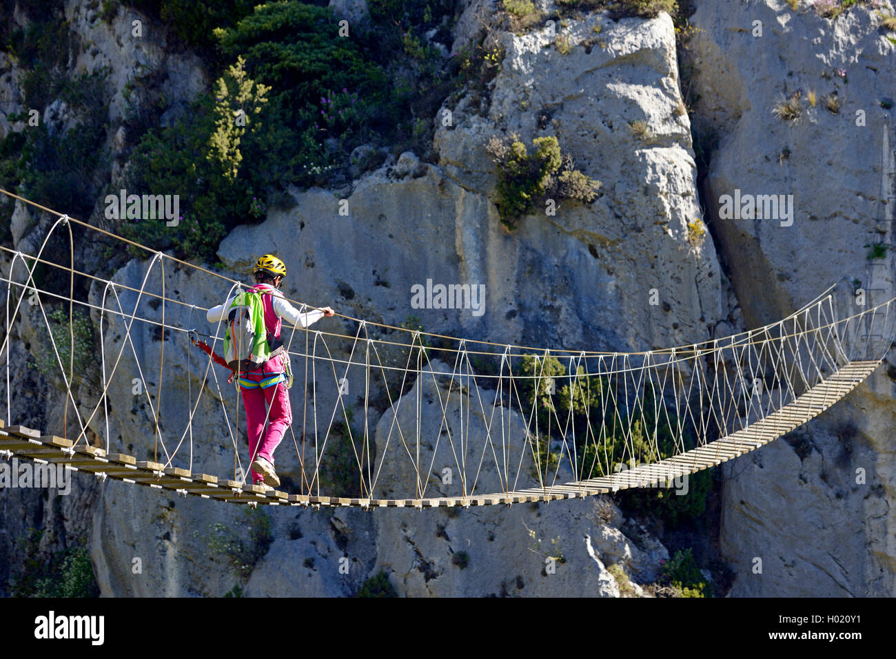 female climber on hanging bridge, via ferrata Escale a Peille, France, Caire, Peillon Stock Photo