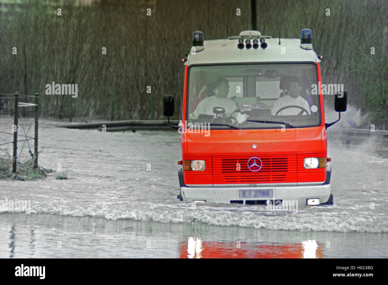 ambulance vehicle passing through high water, Germany, North Rhine-Westphalia Stock Photo