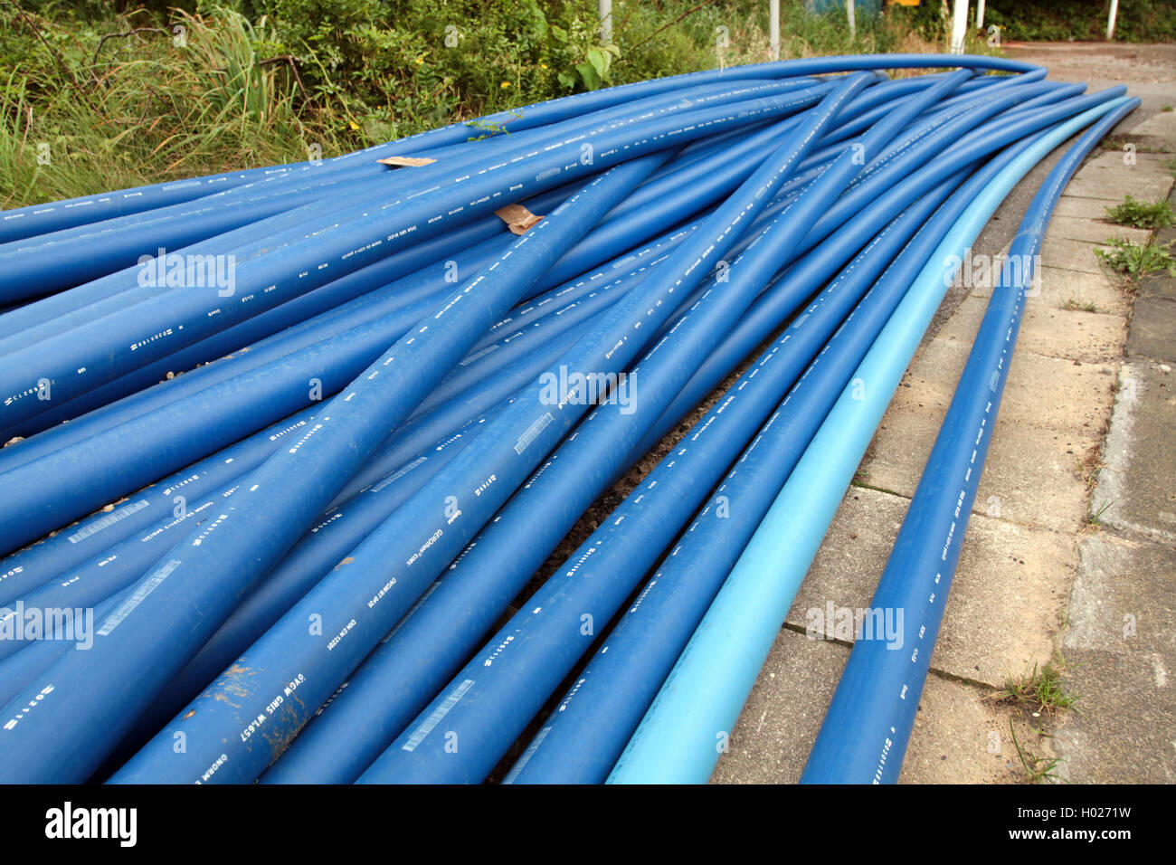 several waterpipes made of plastic lying on a path, Germany Stock Photo