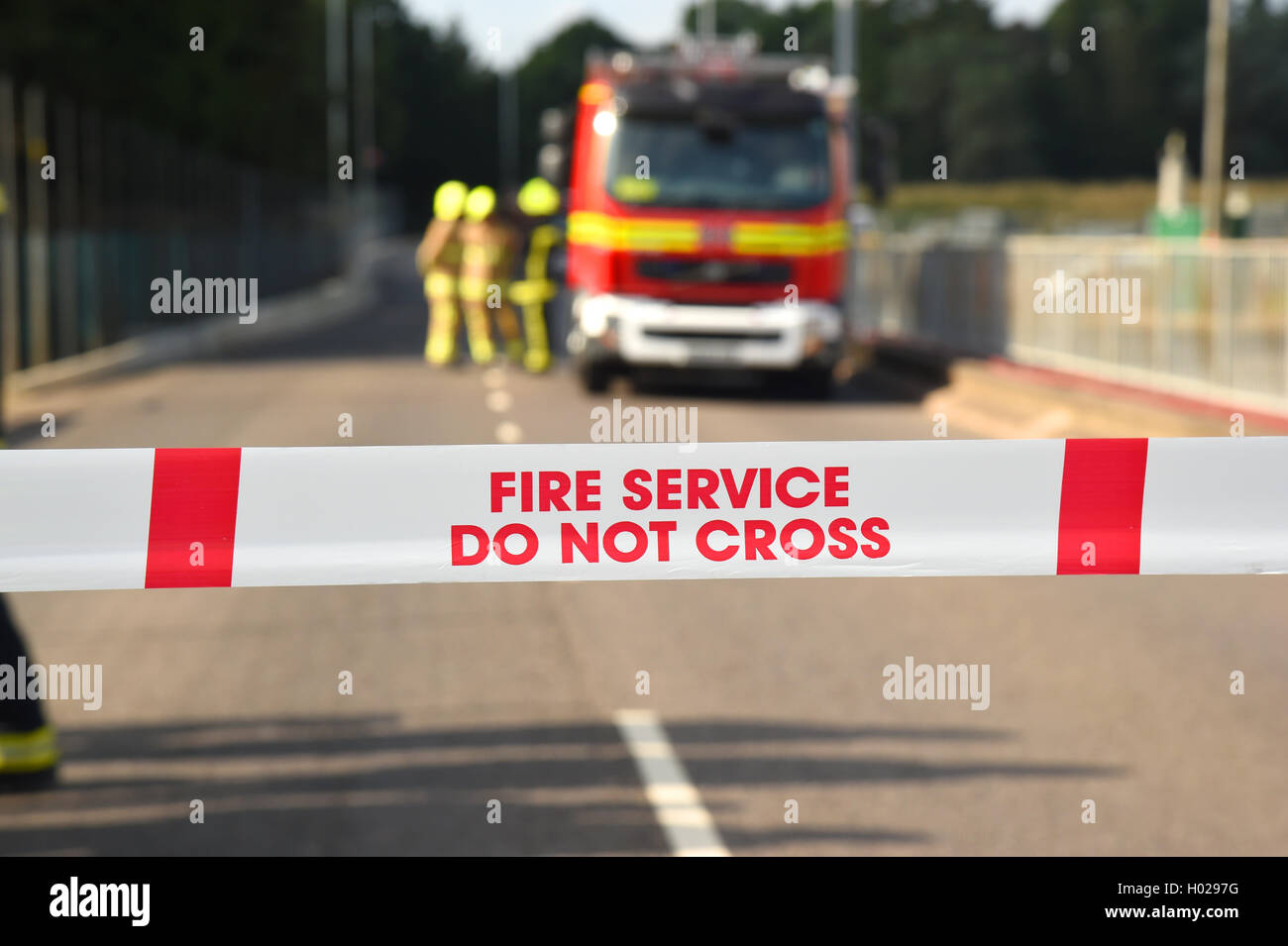 Firefighters at the scene of a major incident. Cordon tape and good depth with selective focus. Stock Photo