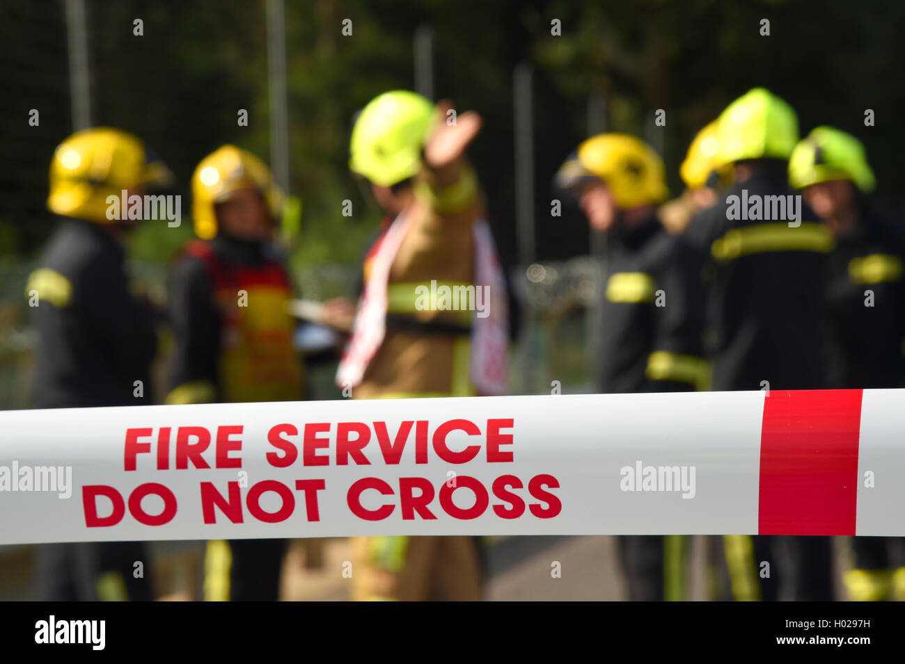 Firefighters at the scene of a major incident. Cordon tape and good depth with selective focus. Stock Photo