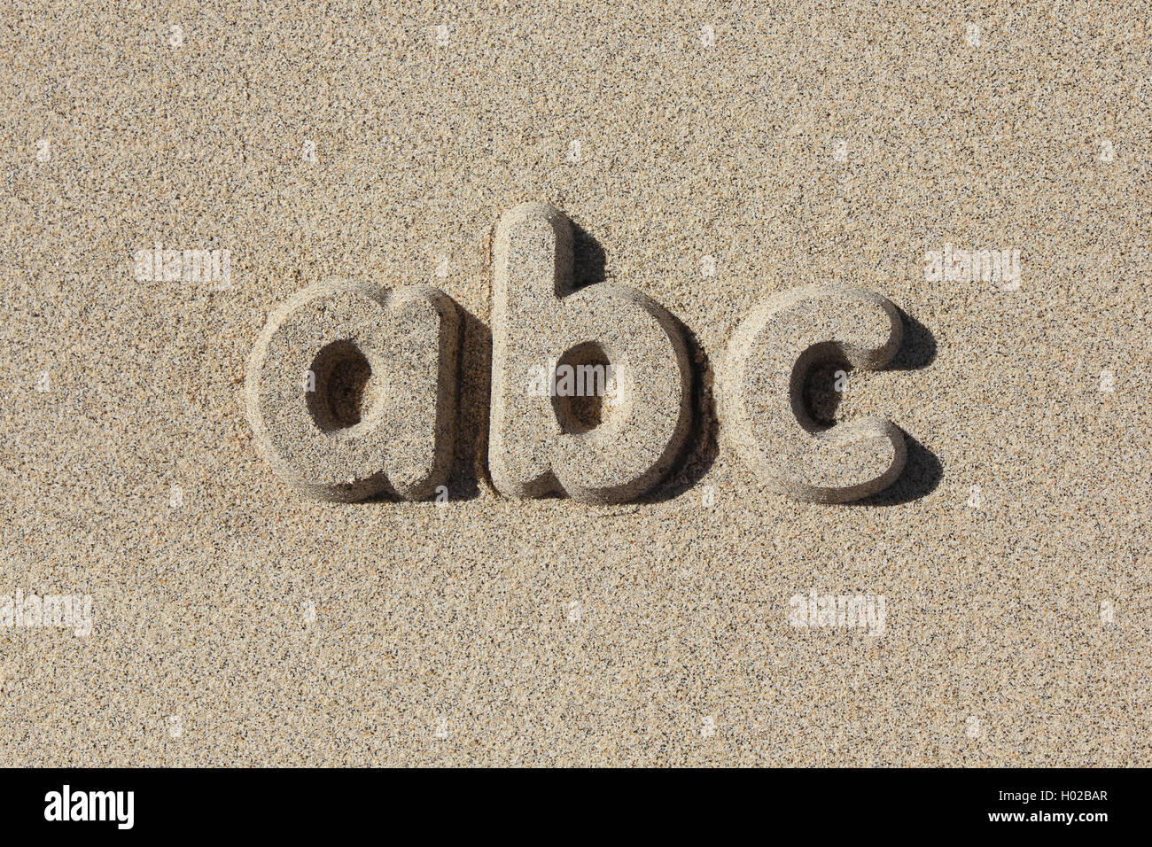 Abc written in sand letters. Simple and graphic Stock Photo - Alamy