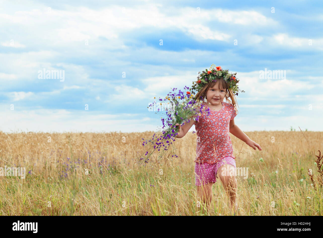 beautiful little girl with a wreath in the wheat field Stock Photo - Alamy