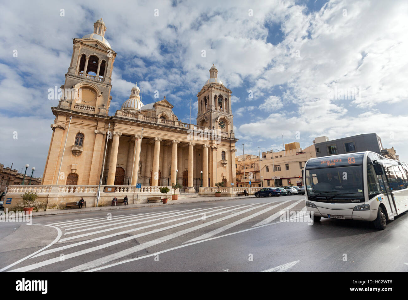 PAOLA, MALTA - JANUARY 12, 2015: Public bus in front of Church of Christ the King. Stock Photo