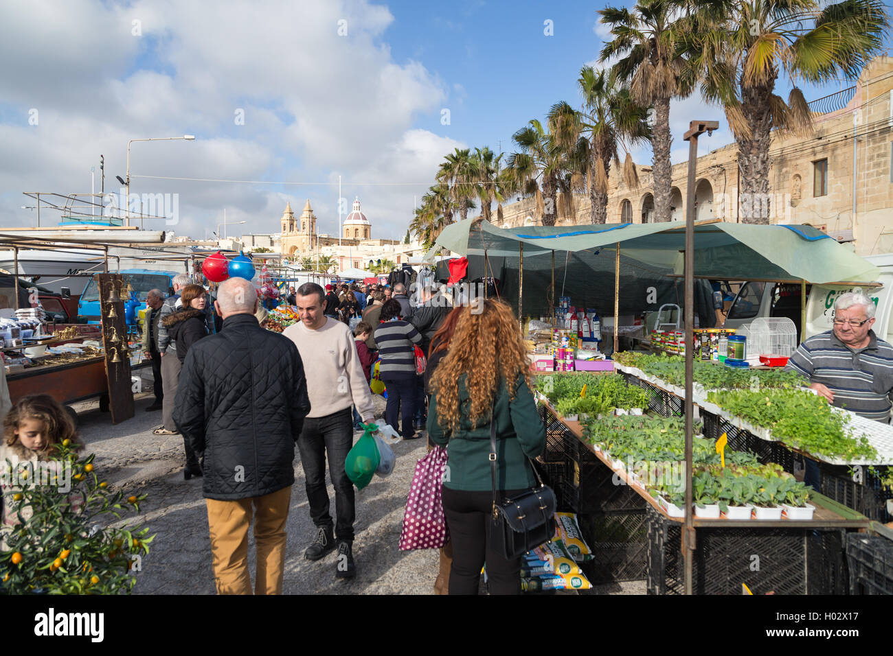 MARSAXLOKK, MALTA - JANUARY 11, 2015: People at Marsaxlokk market, one of the city's main features especially on sunday. Stock Photo