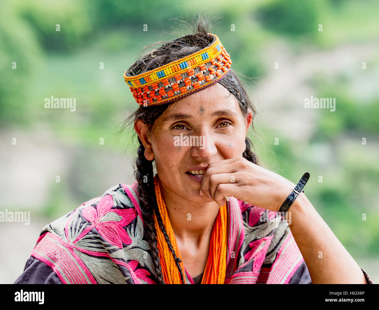 Kalash woman in traditional dress with her hand half covering her mouth Stock Photo