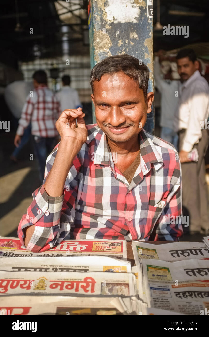 MUMBAI, INDIA - 08 JANUARY 2015: India man selling newspapers in front of train station. Stock Photo