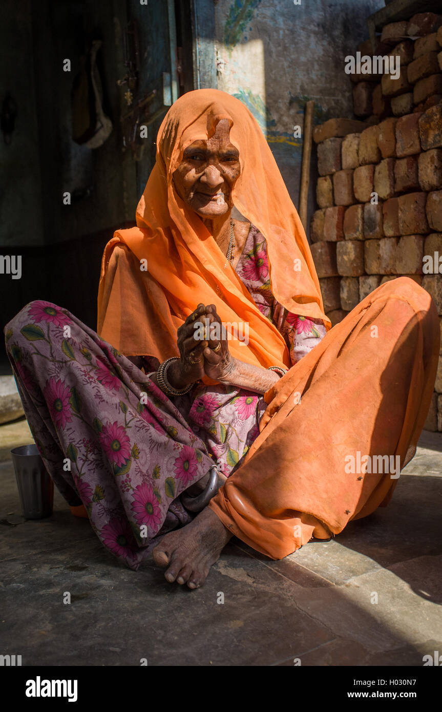 GODWAR REGION, INDIA - 13 FEBRUARY 2015: Elderly Indian woman in sari with covered head sits in doorway of home. Stock Photo