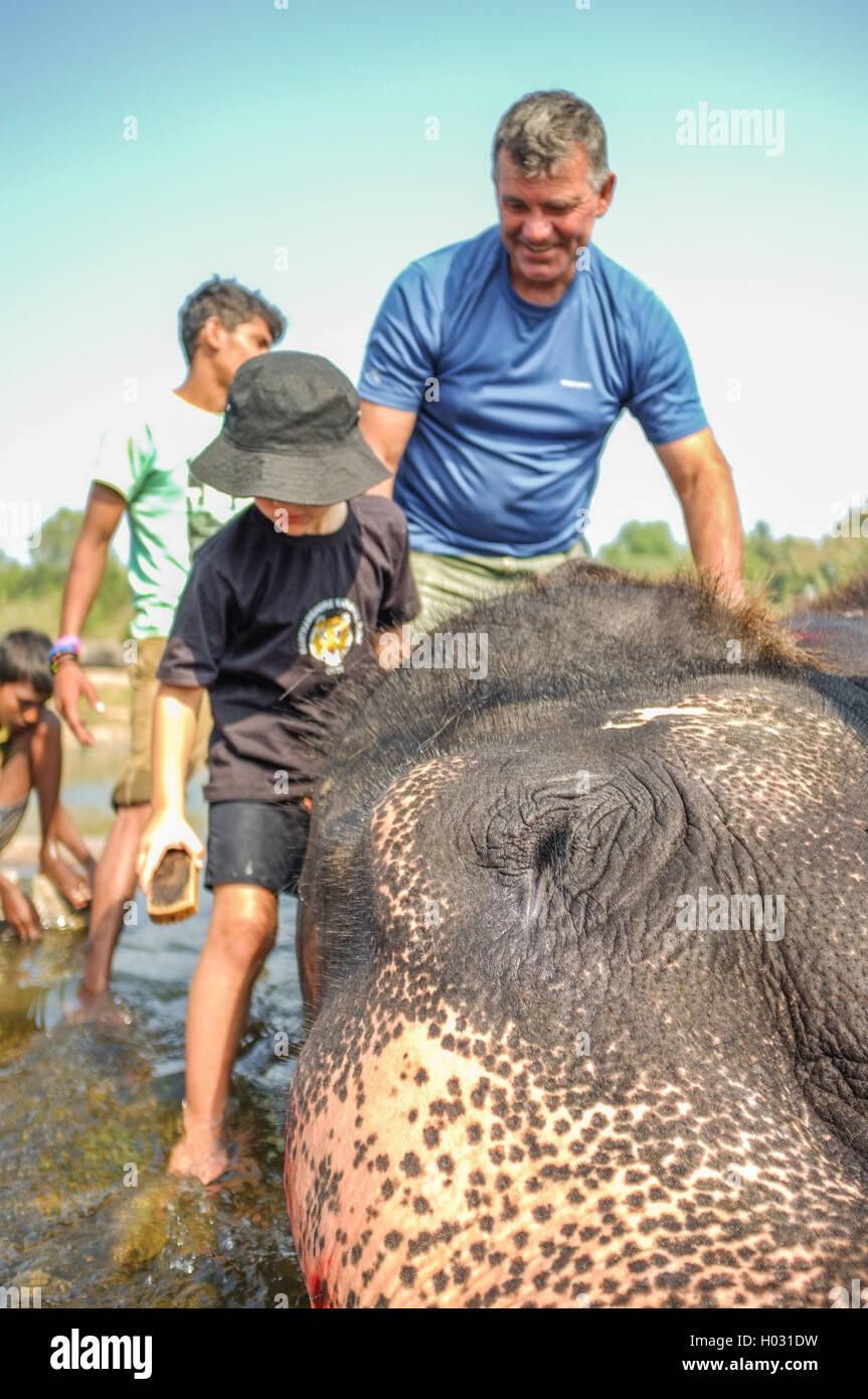 HAMPI, INDIA - 28 JANUARY 2015: Morning ritual of bathing Lakshmi the temple elephant of Virupaksha Temple with tourists Stock Photo