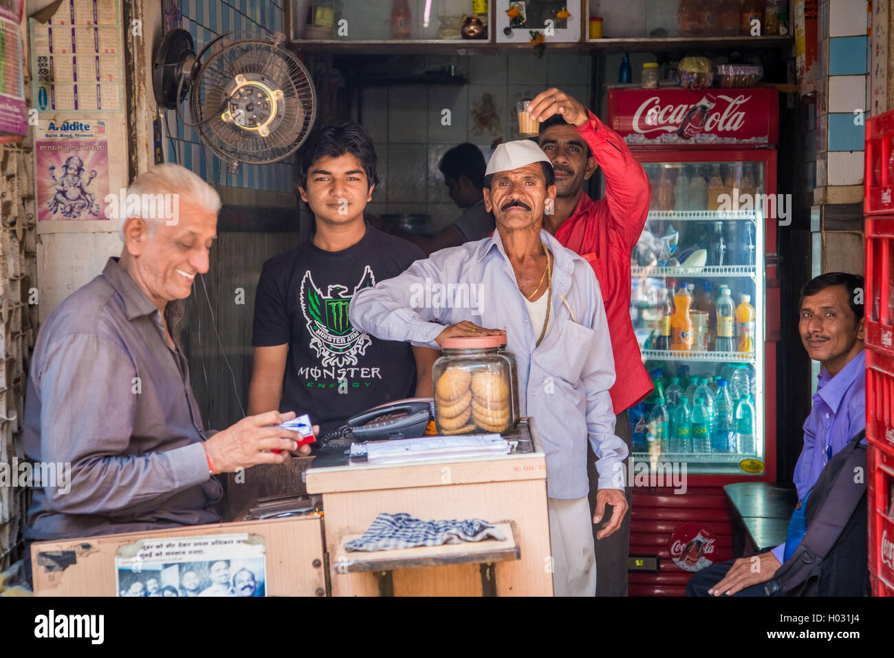 MUMBAI, INDIA - 17 JANUARY 2015: Street scene with men in front of small shop in town. Stock Photo