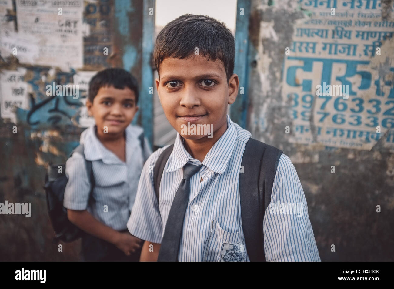 MUMBAI, INDIA - 12 JANUARY 2015: Indian school boys on bridge in Dharavi slum. Post-processed with grain, texture and colour eff Stock Photo