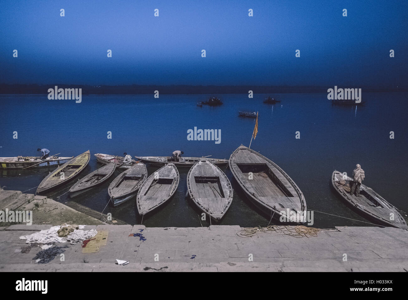 VARANASI, INDIA - 20 FEBRUARY 2015: Local guides prepare tourist boats next to Varanasi ghats. Post-processed with grain, textur Stock Photo