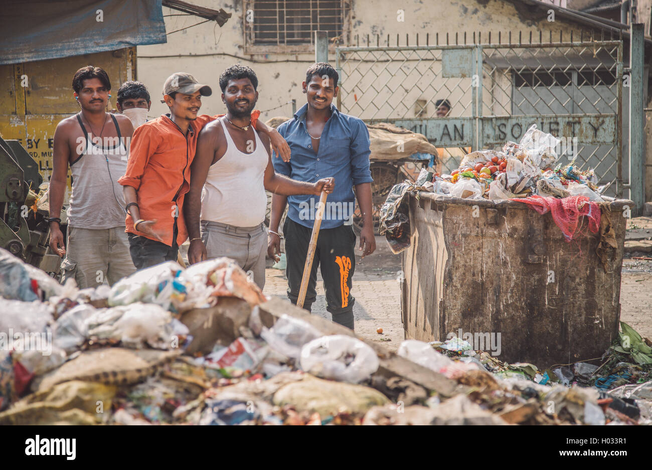 MUMBAI, INDIA 16 JANUARY 2015 Five adult garbage men pile up garbage
