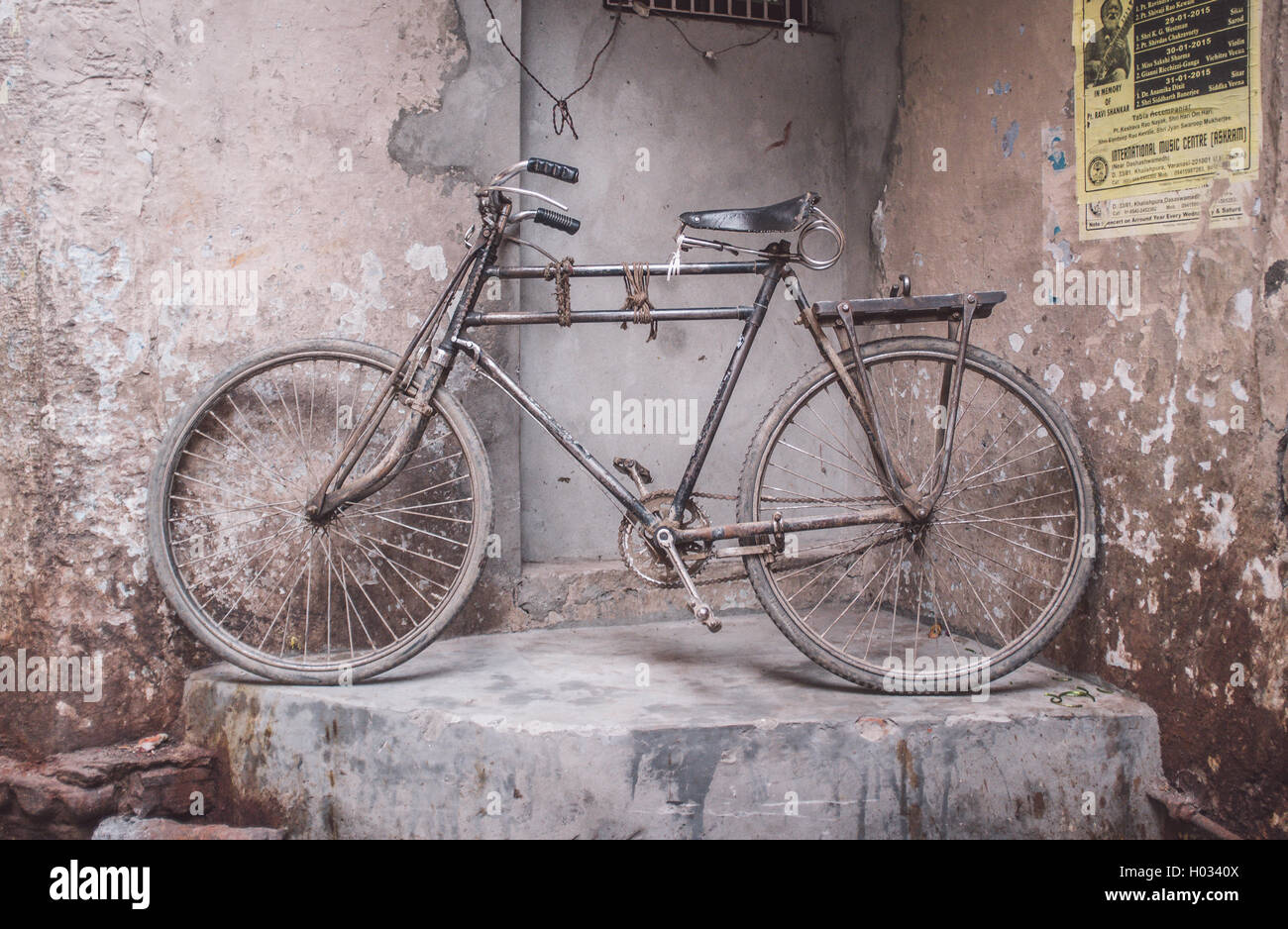 VARANASI, INDIA - 25 FEBRUARY 2015: Traditional Indian bicycle parked in corner of street. Post-processed with grain, texture an Stock Photo