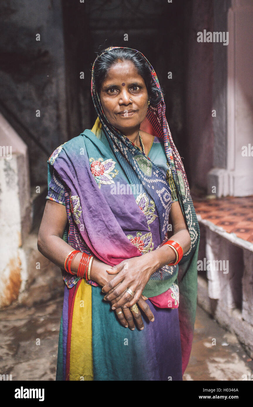 VARANASI, INDIA - 20 FEBRUARY 2015: Indian woman in colorful sari with bindi stands in street. Post-processed with grain, textur Stock Photo